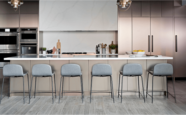 A series of JennAir Column refrigerators in a modern, elevated kitchen. 